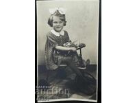 Little girl on a tricycle with her dolls