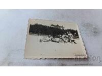 Photo: Men and Young Men Under Umbrella on the Beach