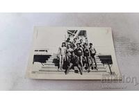 Fotografie Tineri și tinere în costume de baie pe scări