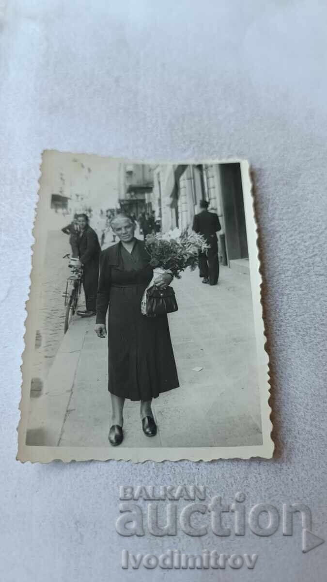 Photo Sofia Woman with a bouquet of flowers on the sidewalk