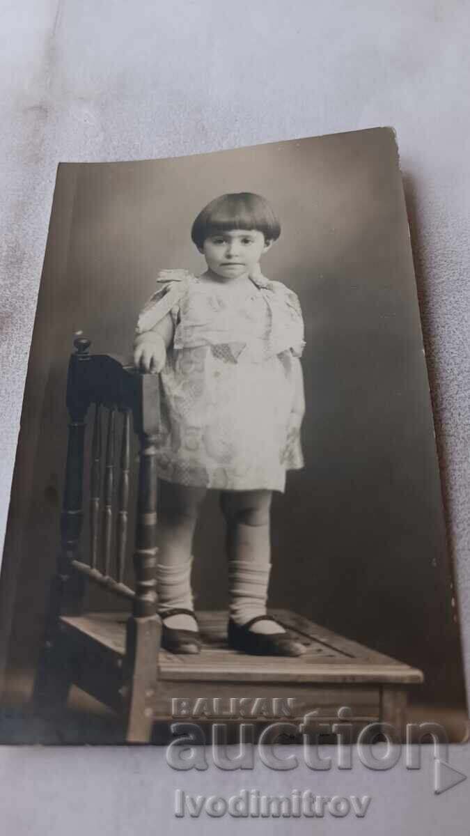 Photo of a Little Girl Sitting on a Chair