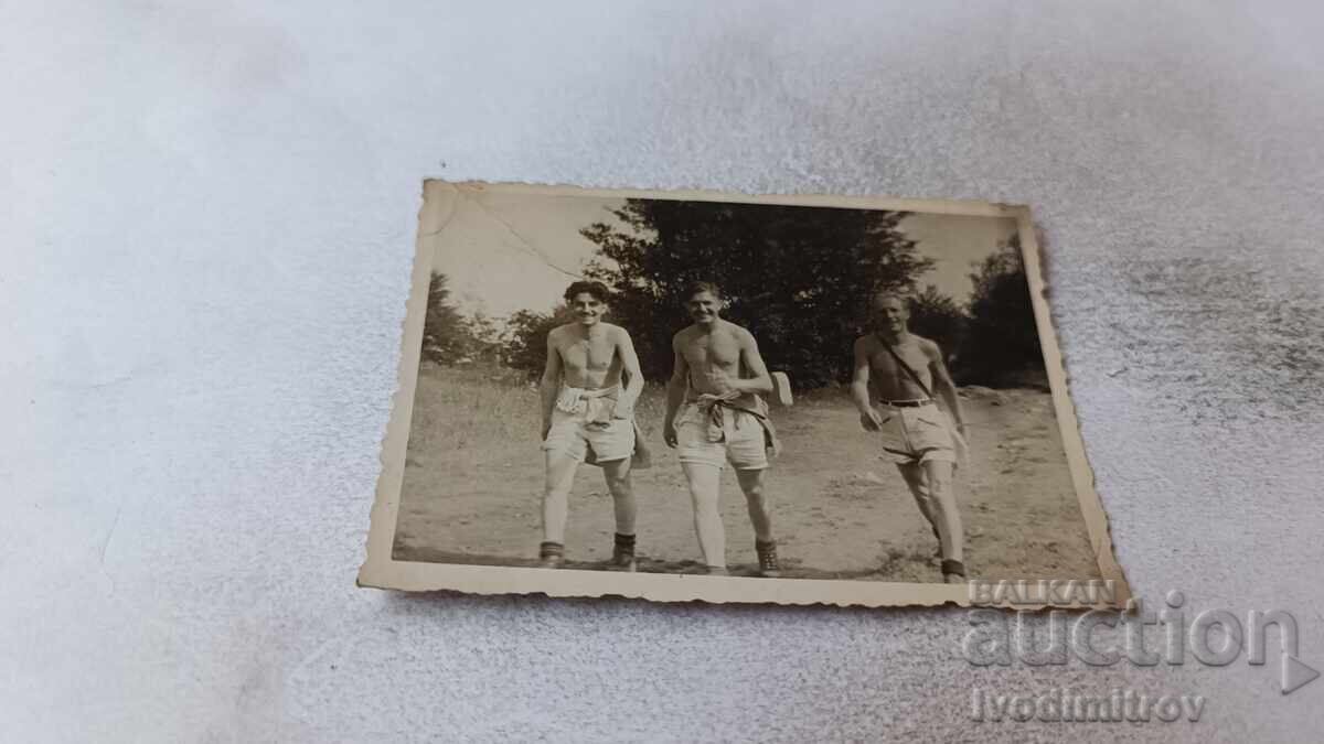 Φωτογραφία Τρεις άνδρες με κοντά παντελόνια και γυμνοί από τη μέση και πάνω