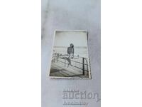 Fotografie Fată tânără așezată pe o balustradă