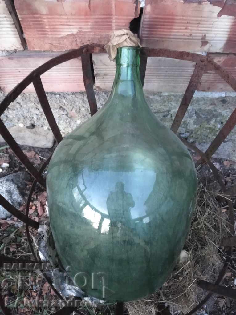 Auction  Large glass demijohn with a metal basket