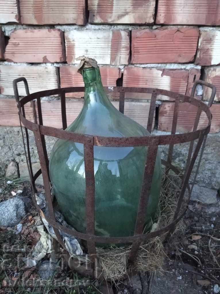 Large glass demijohn with a metal basket