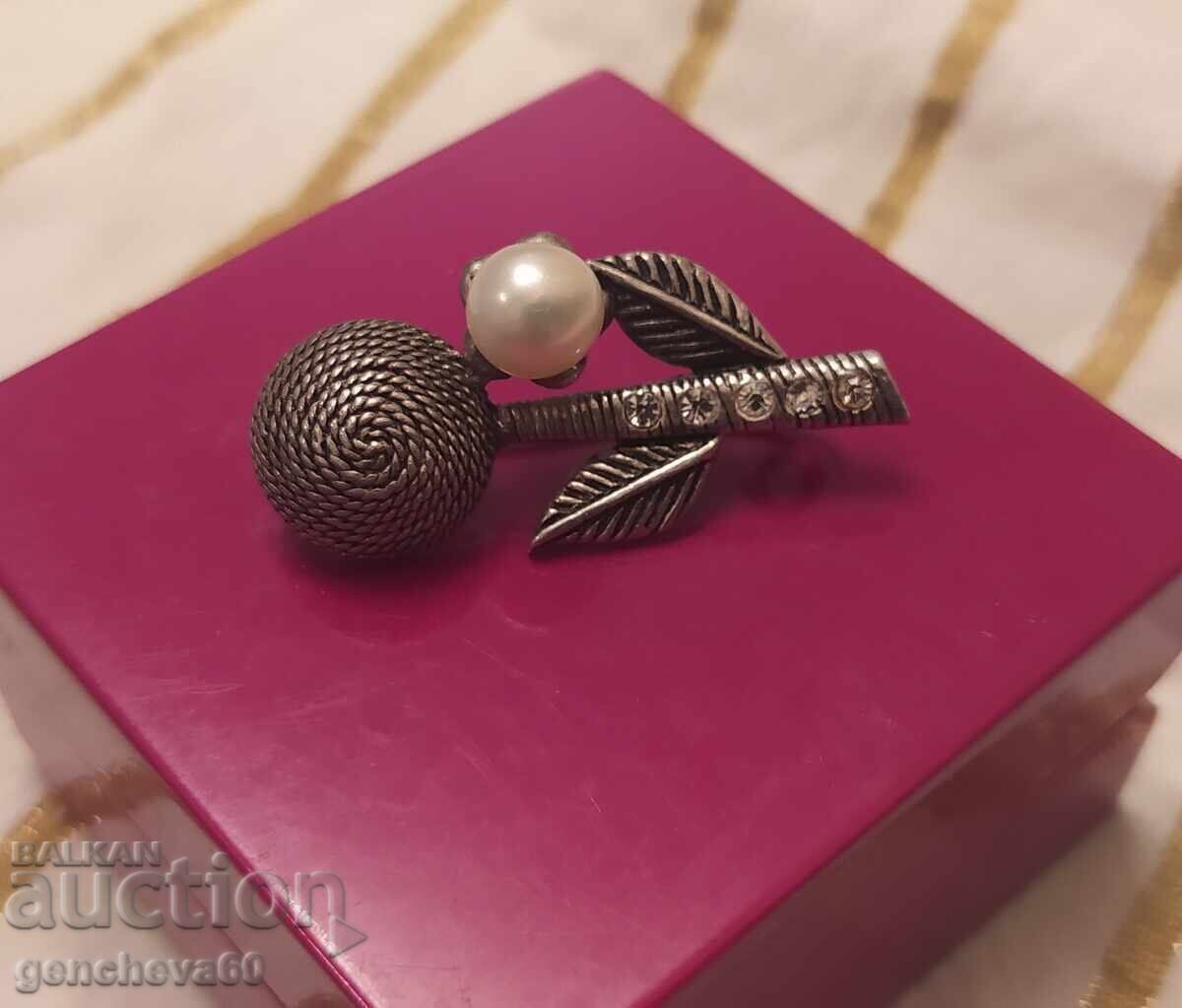Old silver brooch with a pearl