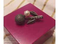 Old silver brooch with a pearl