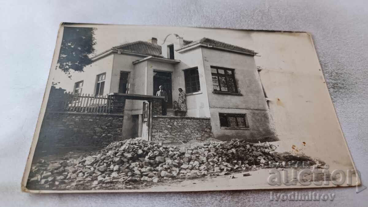 Photo of a man, woman, and little girl in front of a single-family house Photo of a man, woman, and little girl in front of a single-family house