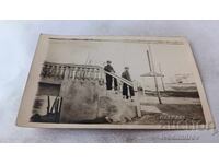 Photo of Two Young People on a Bridge Over a River