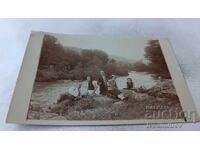 Φωτογραφία Άνδρες και νεαρές γυναίκες δίπλα στο ποτάμι