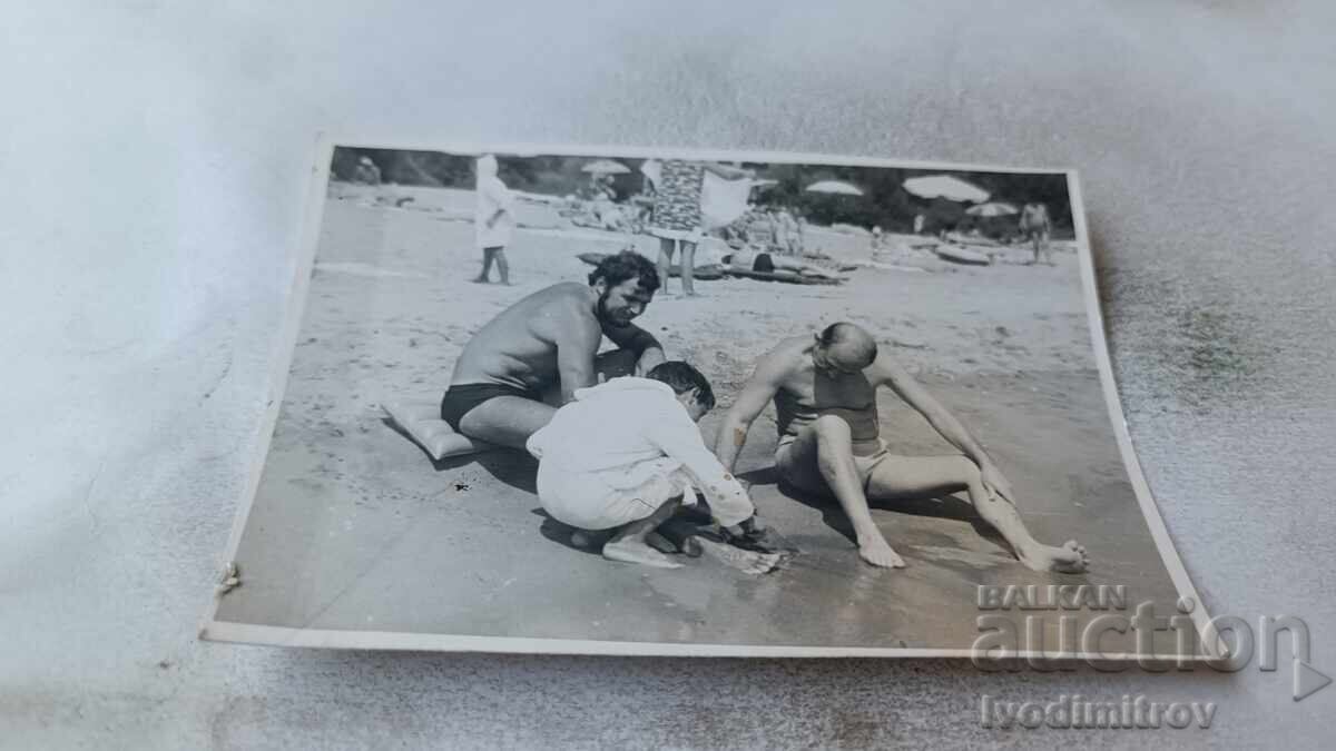 Φωτογραφία Δύο άντρες και ένα αγόρι στην παραλία Φωτογραφία Δύο άντρες και ένα αγόρι στην παραλία