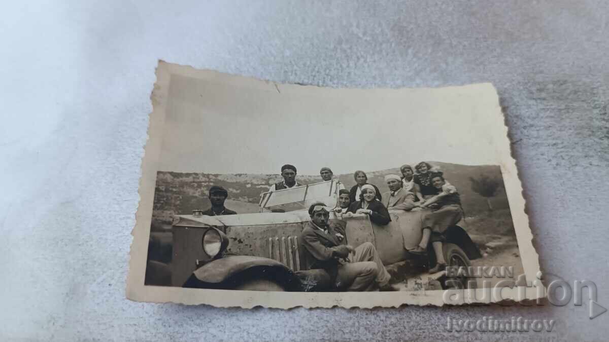 Foto Bărbați și femei cu o mașină retro