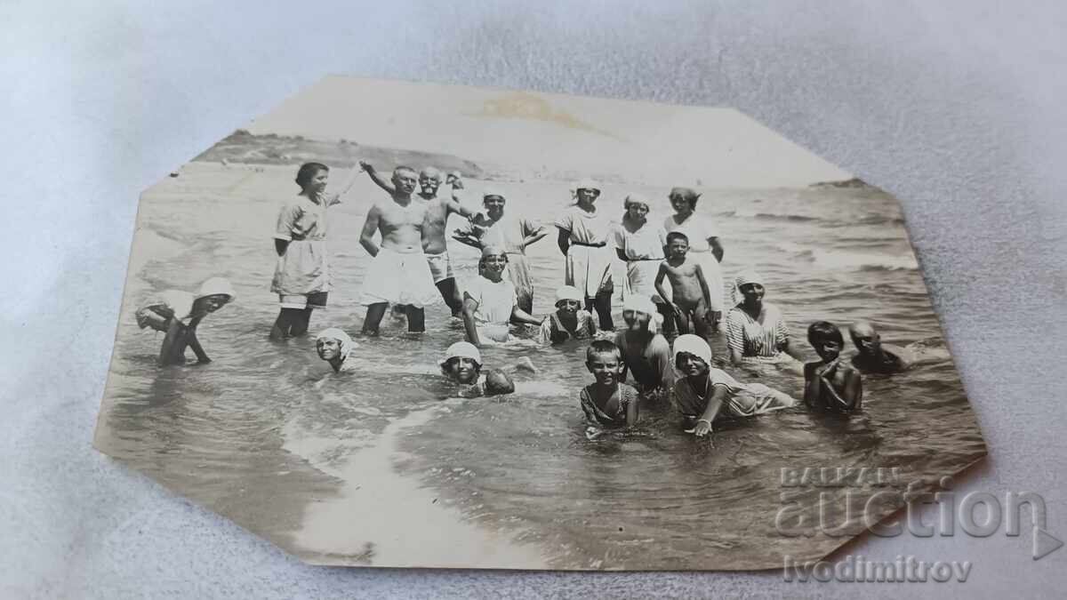 Φωτογραφία Μεσημβρία Άνδρες γυναίκες και παιδιά στην παραλία