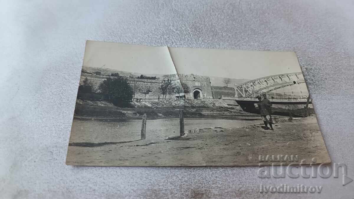 Photograph of Two Officers in Front of a Railway Bridge Over a Large River