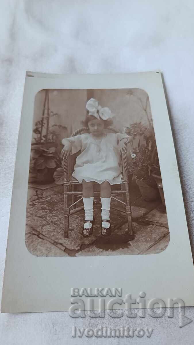 Φωτογραφία Αγοράκι με λευκό φόρεμα καθισμένο σε πλεκτό καρέκλα 1924 Φωτογραφία Αγοράκι με λευκό φόρεμα καθισμένο σε πλεκτό καρέκλα 1924