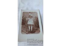 Fotografie Băiețel cu rochiță albă șezând pe un scaun împletit 1924