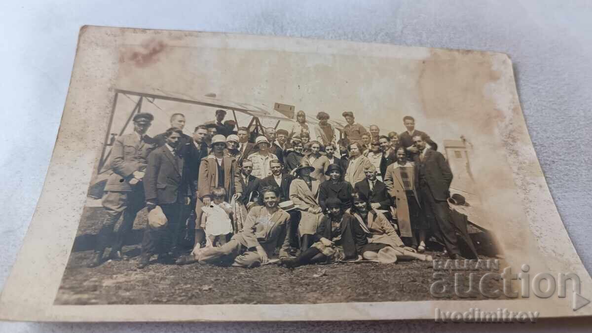 Φωτογραφία Άνδρες και γυναίκες μπροστά σε διπλάνο Φωτογραφία Άνδρες και γυναίκες μπροστά σε διπλάνο