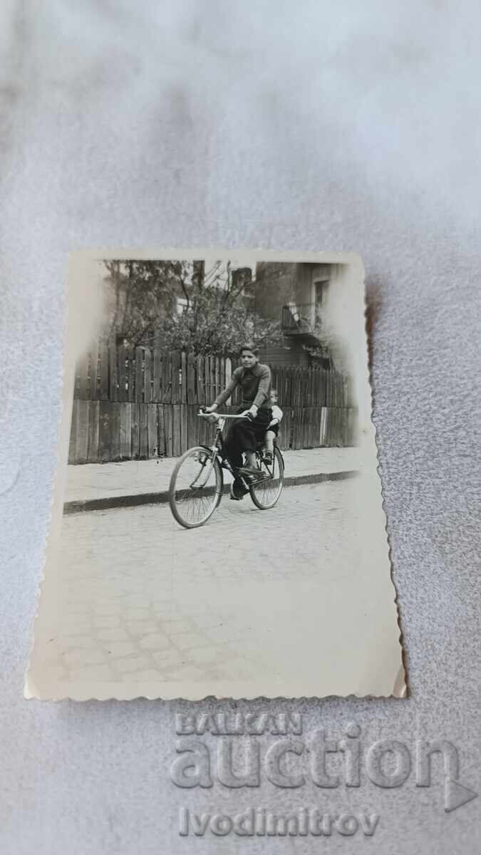 Φωτογραφία Νέου και μικρού αγοριού με ρετρό ποδήλατο