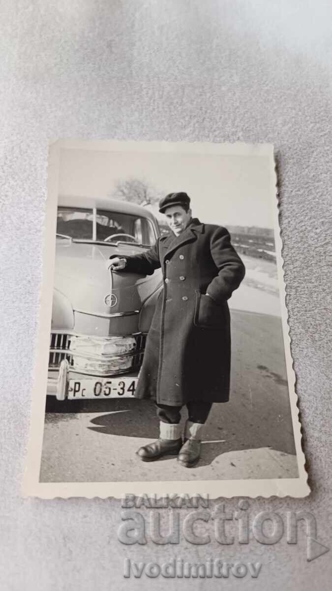 Φωτογραφία Ρούσε Άνδρας σε χειμερινό ένδυμα με ρετρό ελαφρύ αυτοκίνητο. Βαρσοβία Φωτογραφία Ρούσε Άνδρας σε χειμερινό ένδυμα με ρετρό ελαφρύ αυτοκίνητο. Βαρσοβία