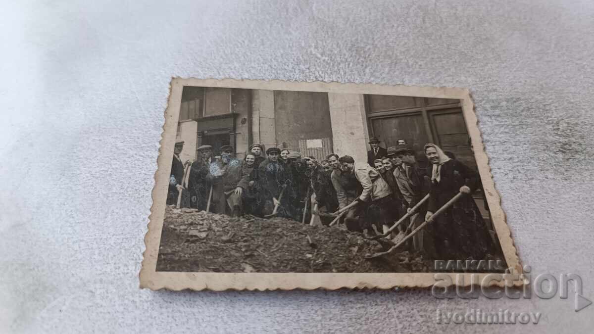 Φωτογραφία Άνδρες και γυναίκες με φτυάρια στον δρόμο