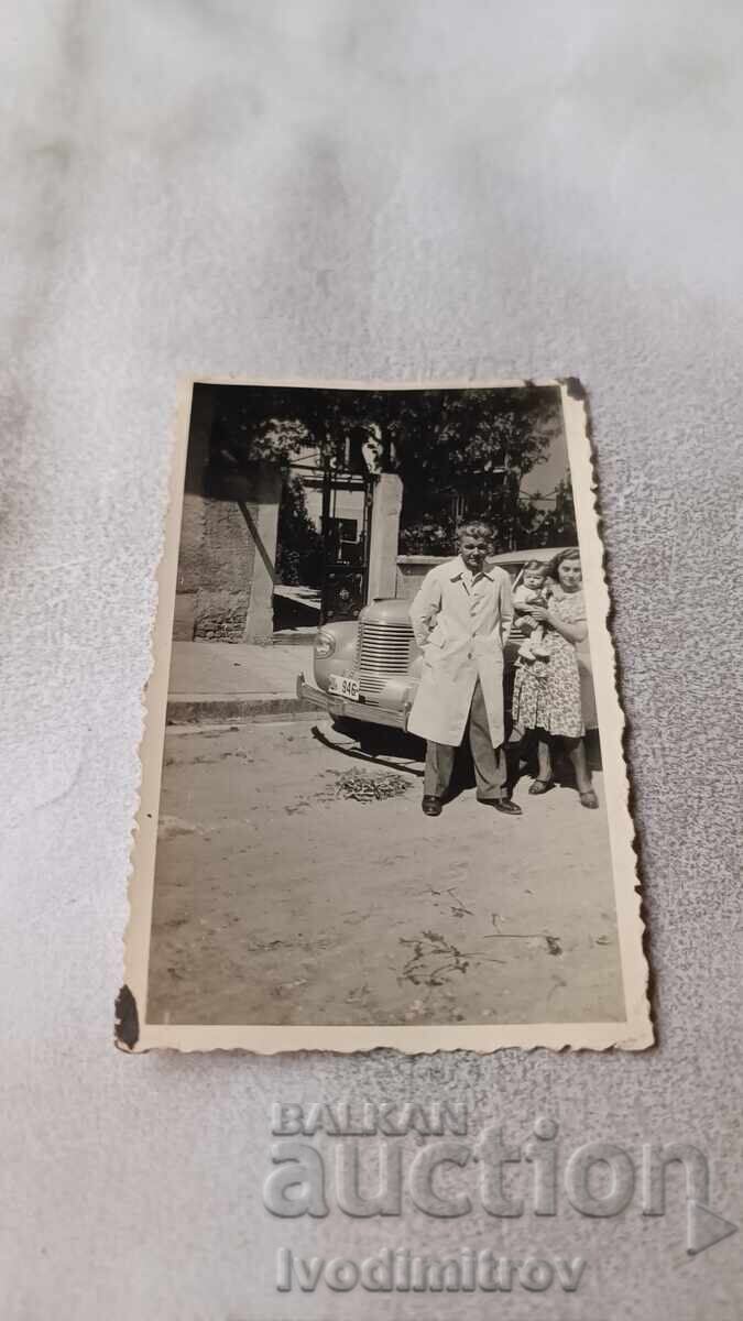 C-car Shumen. Man, woman, and boy near a light car with registration number Shn 946