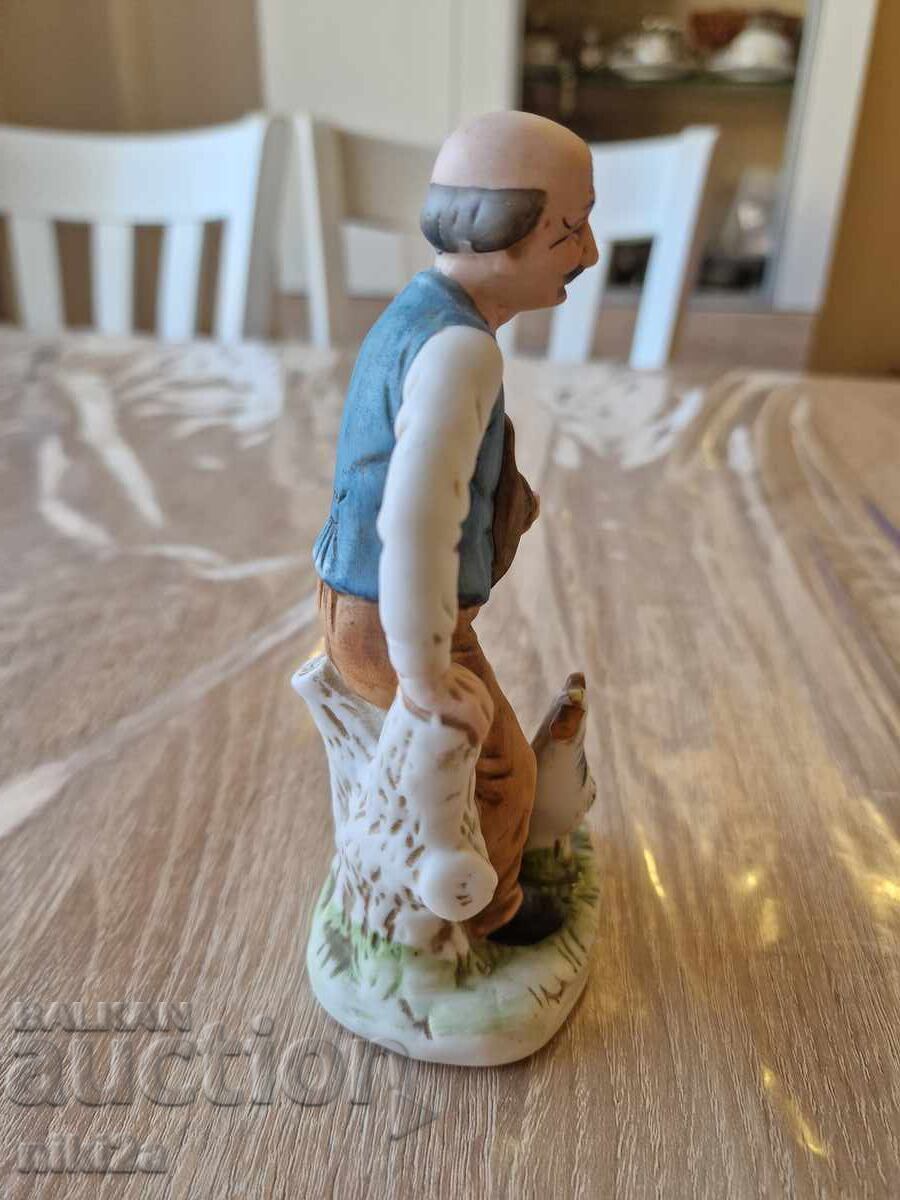 Licitație Bătrân cu o figurină de găină Licitație Bătrân cu o figurină de găină