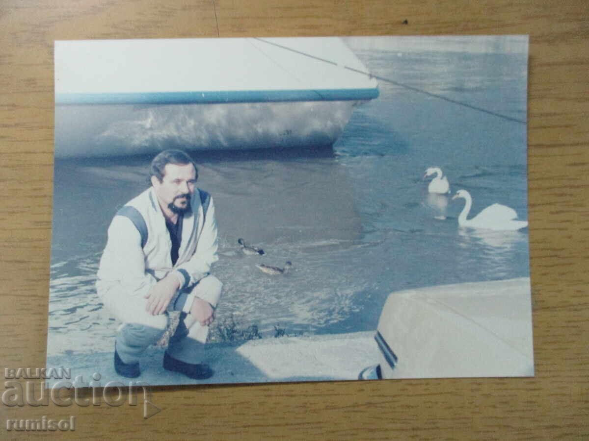 Old photo of a man with swans