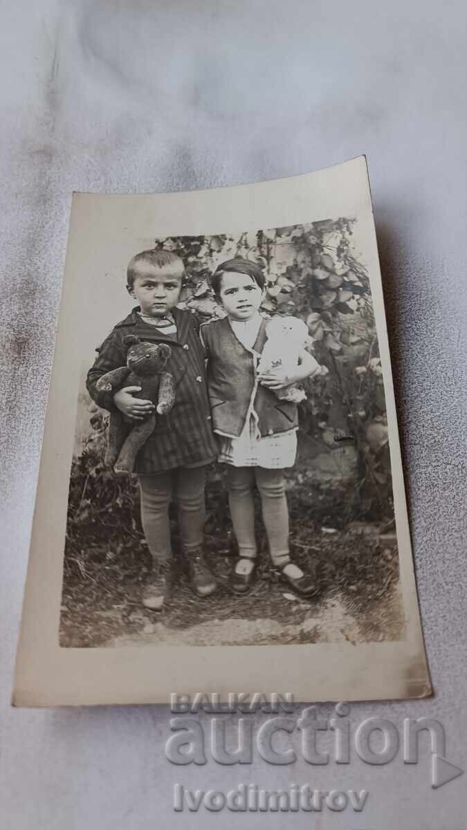 Снимка Брусарци Момченце и момиченце с кукли в ръце Снимка Брусарци Момченце и момиченце с кукли в ръце