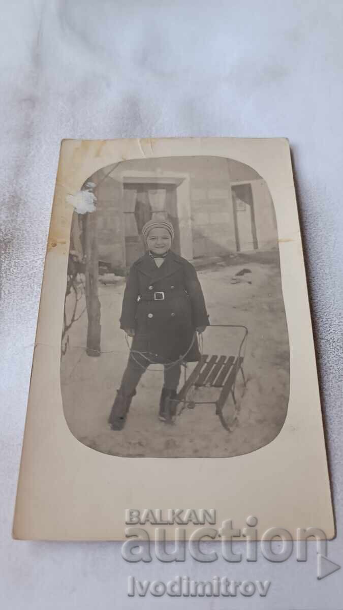 Снимка Момче с шейна в двора на къщата през зимата