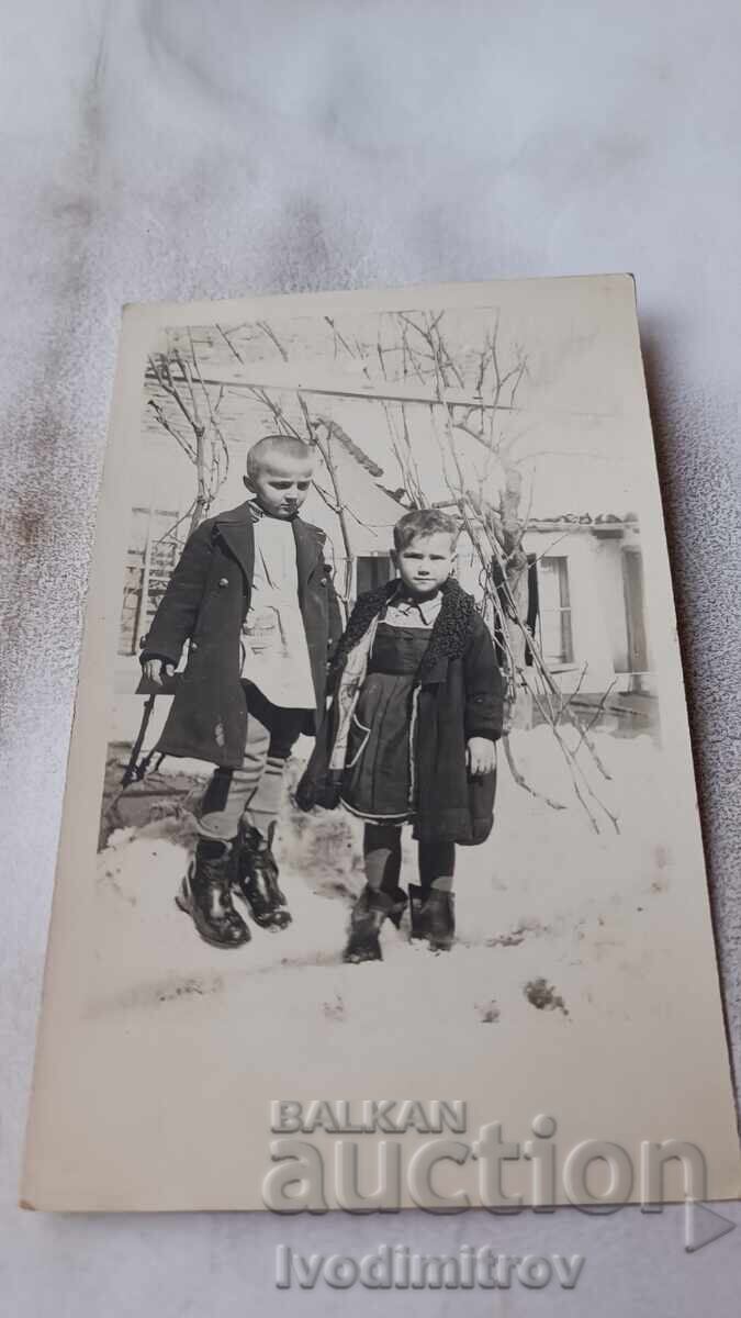 Φωτογραφία Αγοριού και κοριτσιού στην αυλή σπιτιού τον χειμώνα