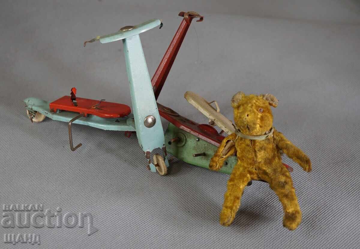 Old mechanical metal toy scooter model with bear Old mechanical metal toy scooter model with bear
