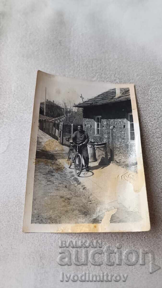 Φωτογραφία Άνδρας με ρετρό ποδήλατο στο πεζοδρόμιο Φωτογραφία Άνδρας με ρετρό ποδήλατο στο πεζοδρόμιο