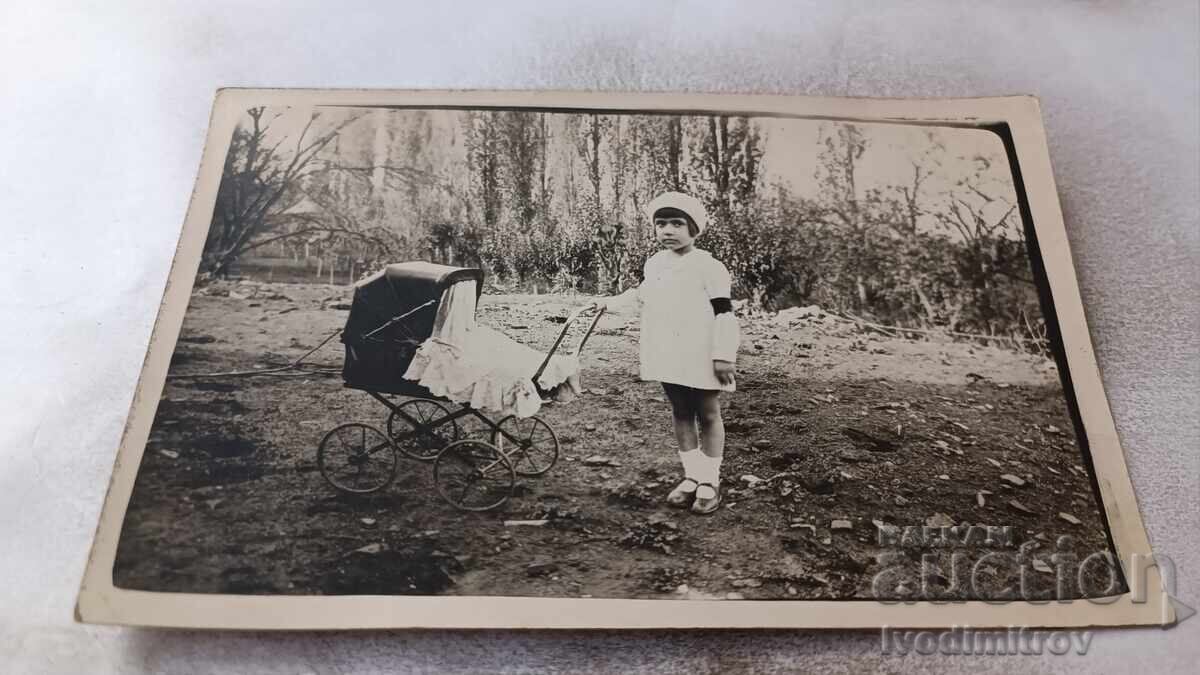 Photo Yambol Girl with retro baby carriage in the park 1929