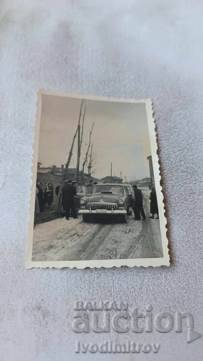 Photo Sofia Men and women with a retro Volga car on the road Photo Sofia Men and women with a retro Volga car on the road