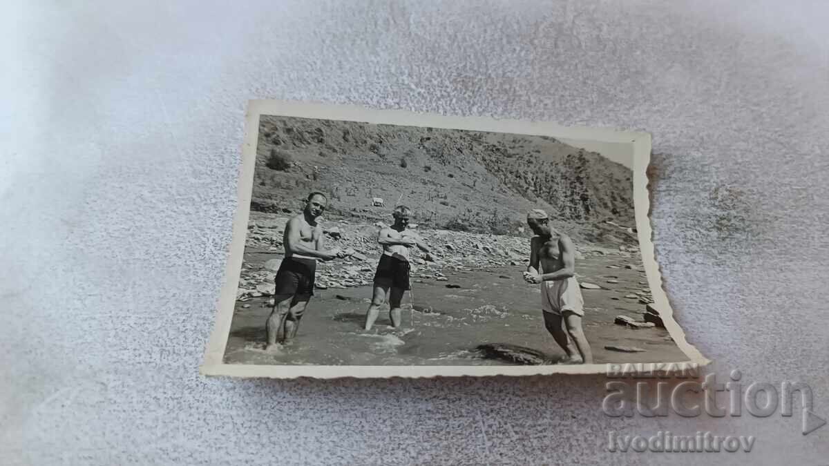 Φωτογραφία Τριών ανδρών που πλένουν ρούχα στο ποτάμι