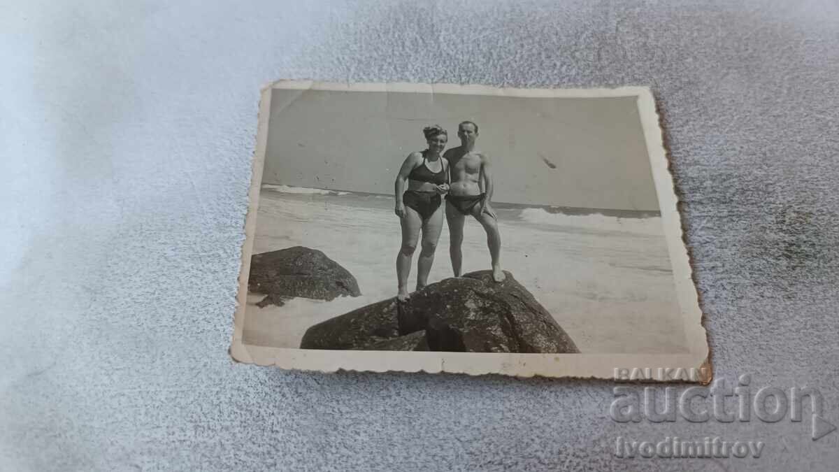 Φωτογραφία Άνδρας και γυναίκα σε βράχο δίπλα στη θάλασσα