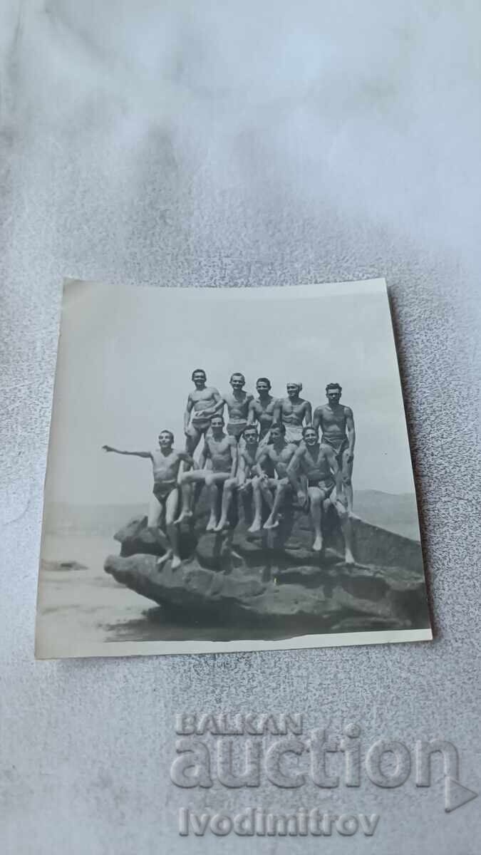 Photo of Young Men on a Cliff by the Sea