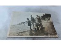 Fotografie cu fete tinere în costume de baie retro pe stânci în mare