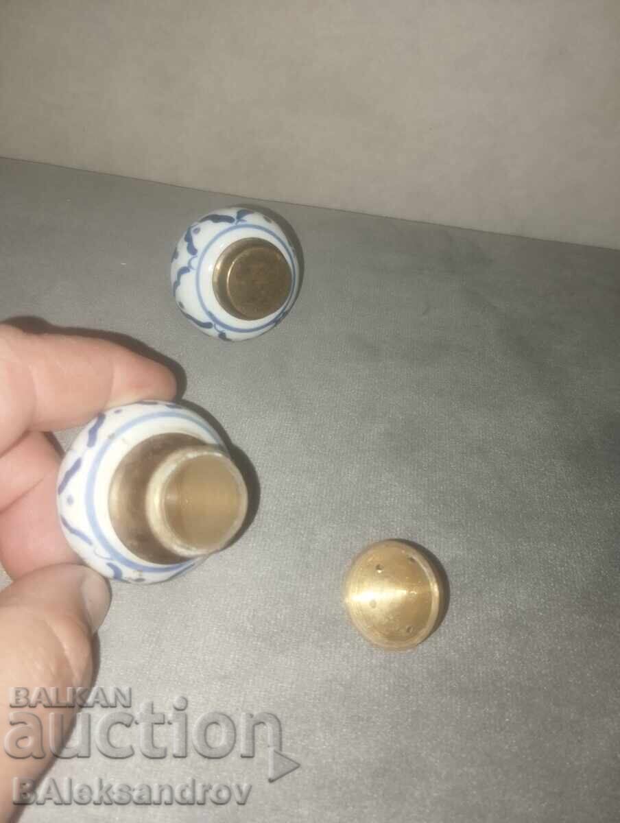 Delivery of Two porcelain salt shakers with brass ornaments