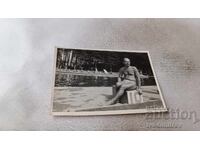 Photo: Man sitting at number 10 of a swimming pool