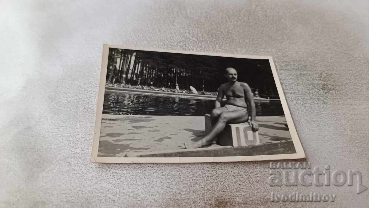 Снимка Мъж седнал на номер 10 на плувен басейн Снимка Мъж седнал на номер 10 на плувен басейн