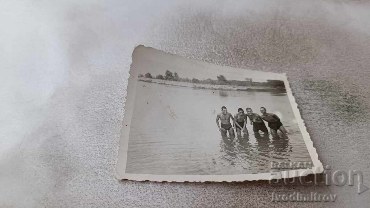 Photo of four young people in retro swimsuits in the sea