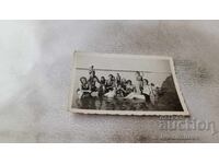 Fotografie cu bărbați, băieți și fete pe plajă