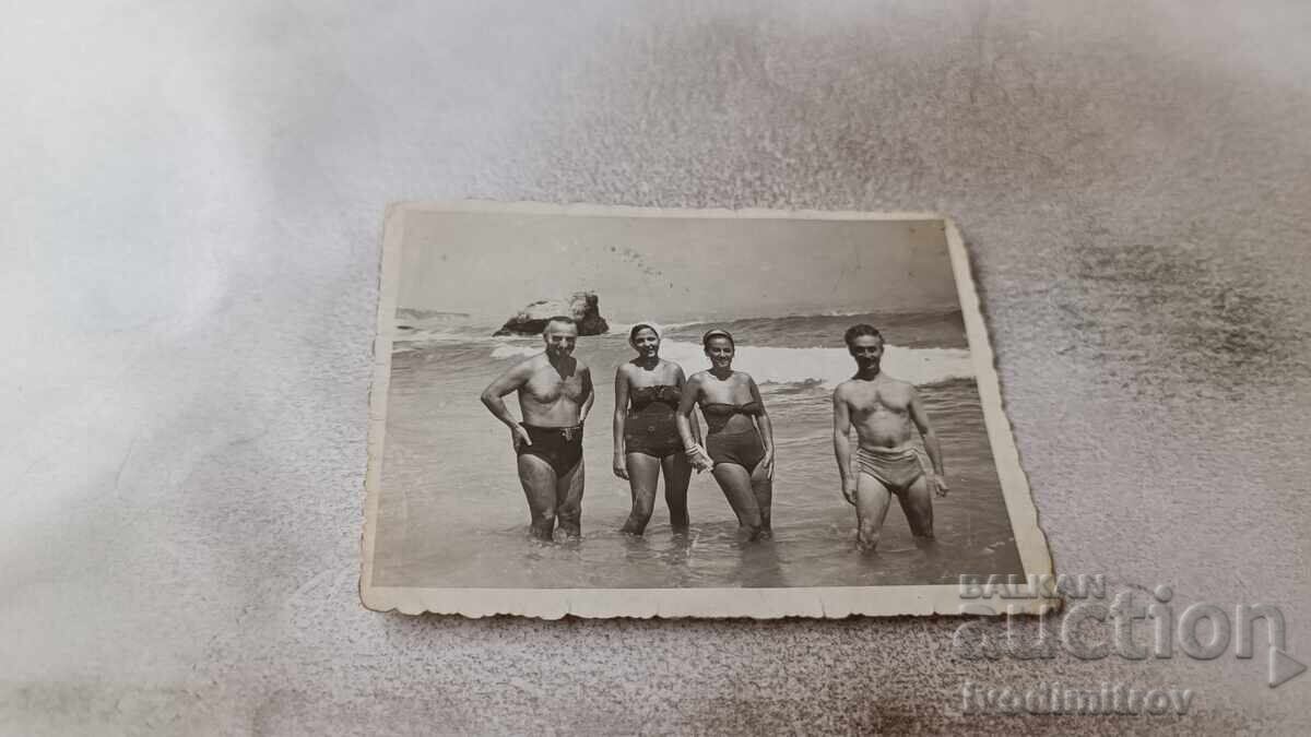 Photo Two men and two young women on the beach