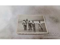 Photo Two men and two young women on the beach