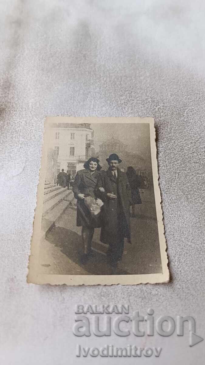 Snimka Sofiya Mŭzh και γυναίκα με μπουκέτο μπροστά από το Sŭsebnata palata