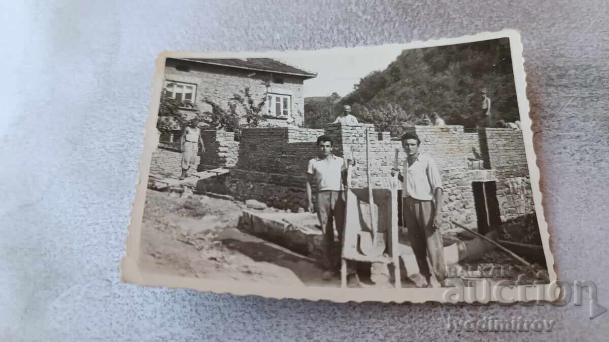 Photo Men in front of a newly built house