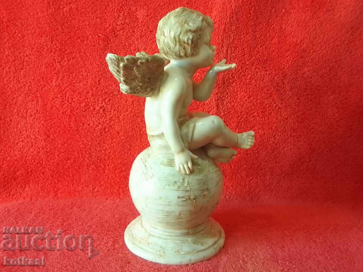 Auction  Old porcelain figure of an Angel sitting on a ball