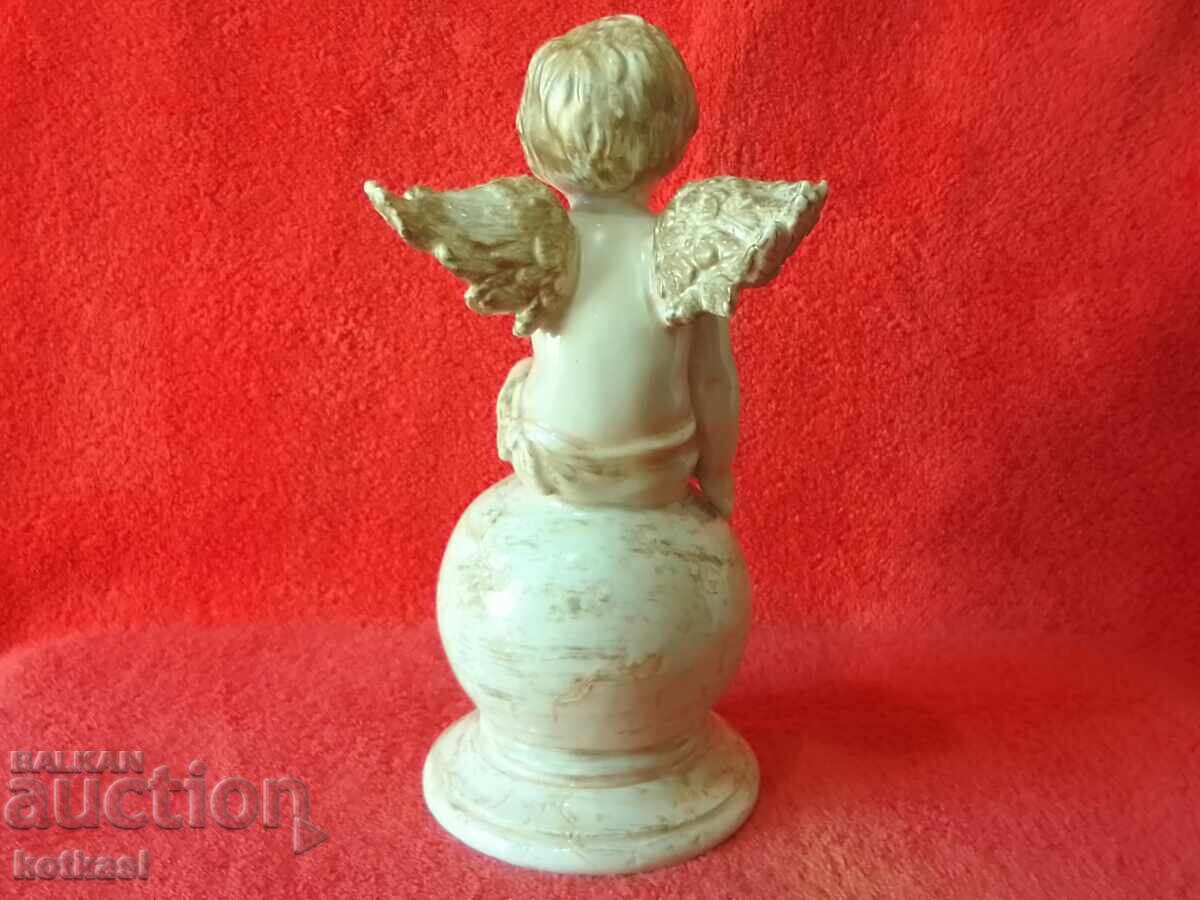 Delivery of Old porcelain figure of an Angel sitting on a ball