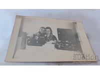 Fotografie Femeie și băiat cu gramofon retro și mașină de cusut pe masă